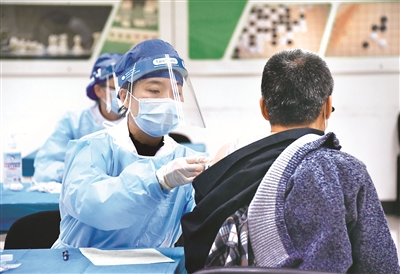 截至目前，北京市新冠疫苗接種人數(shù)突破100萬(wàn)。圖為近日，在北京市海淀區(qū)學(xué)院路街道的一處新冠疫苗接種點(diǎn)，醫(yī)務(wù)人員為接種人員接種新冠疫苗。新華社記者 任超 攝